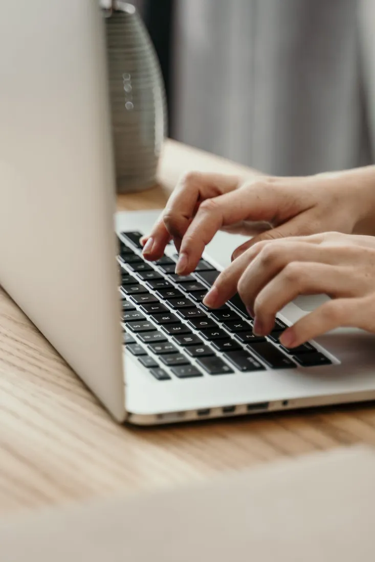 Hände tippen auf der Tastatur eines Laptops