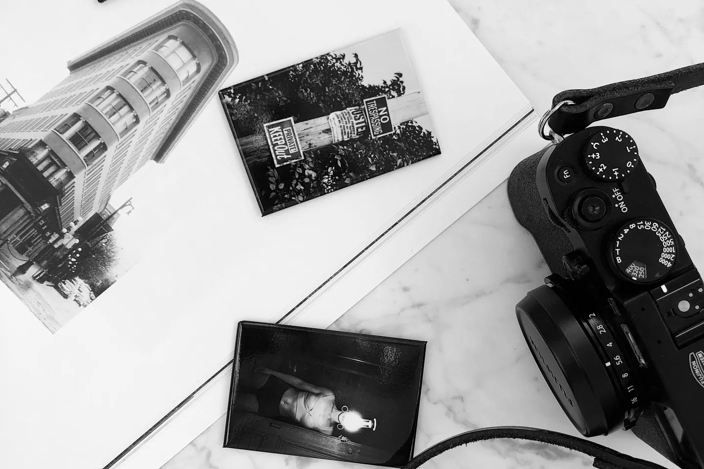 Kamera und Auswahl gedruckter Fotografien auf einem Tisch