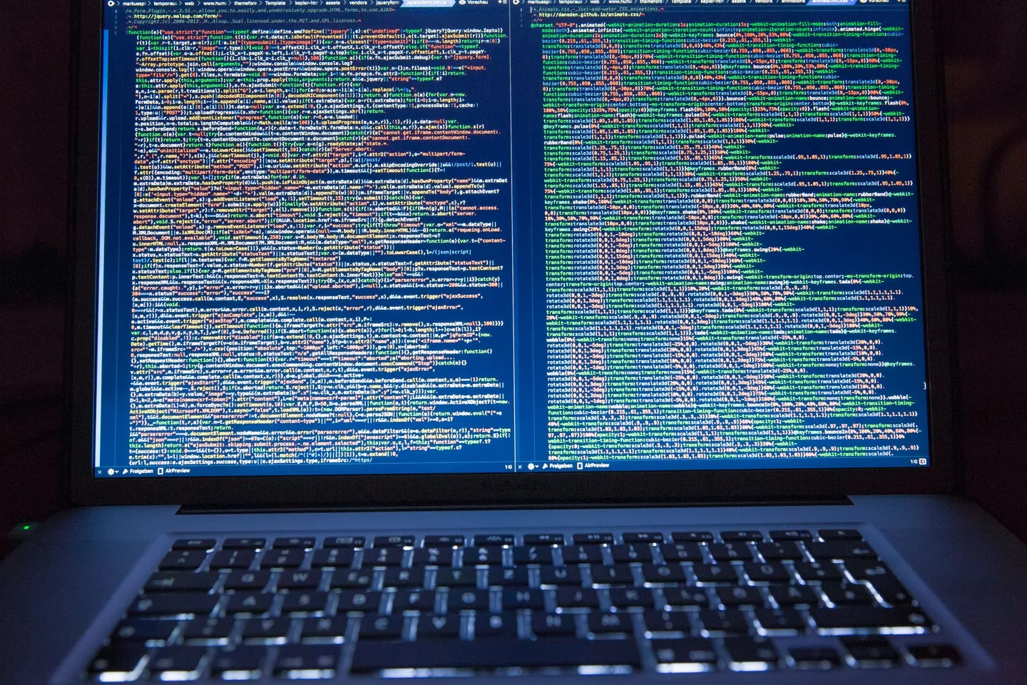 Laptop und Bildschirm mit geöffnetem Programmcode