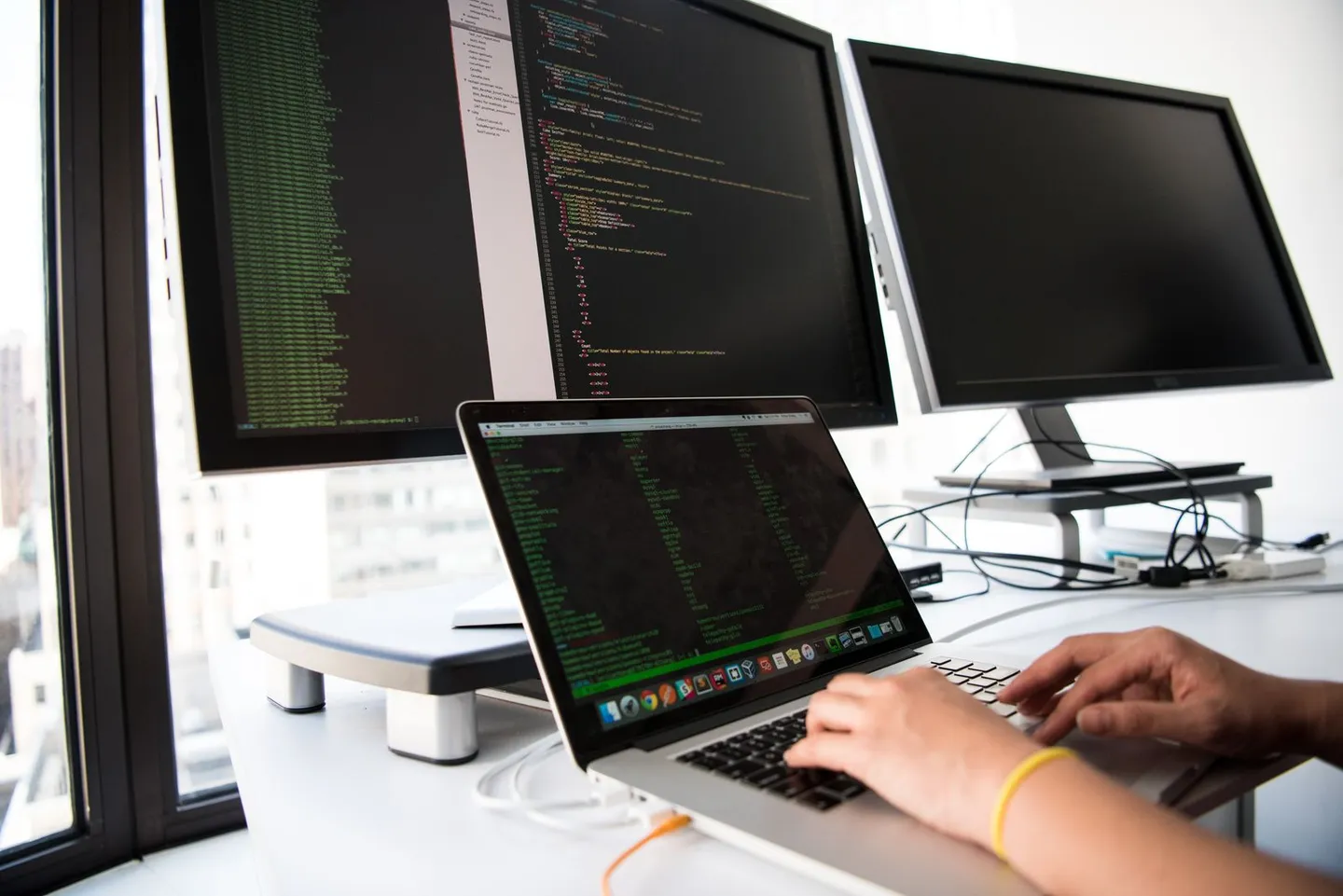 Person schreibt Programmcode an einem Laptop