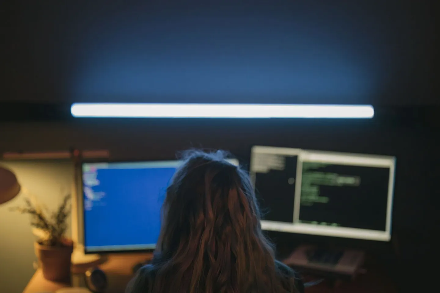 Person arbeitet an einem Computer mit zwei Bildschirmen