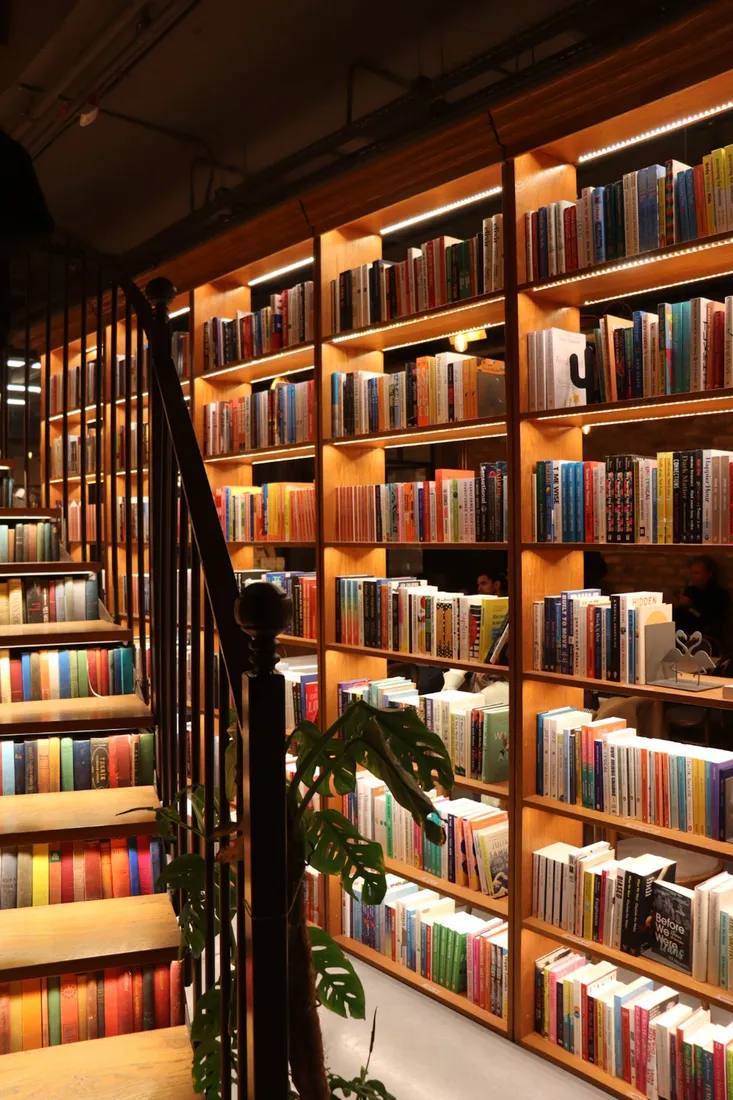 Beleuchtete Bücherregale neben einer Wendeltreppe