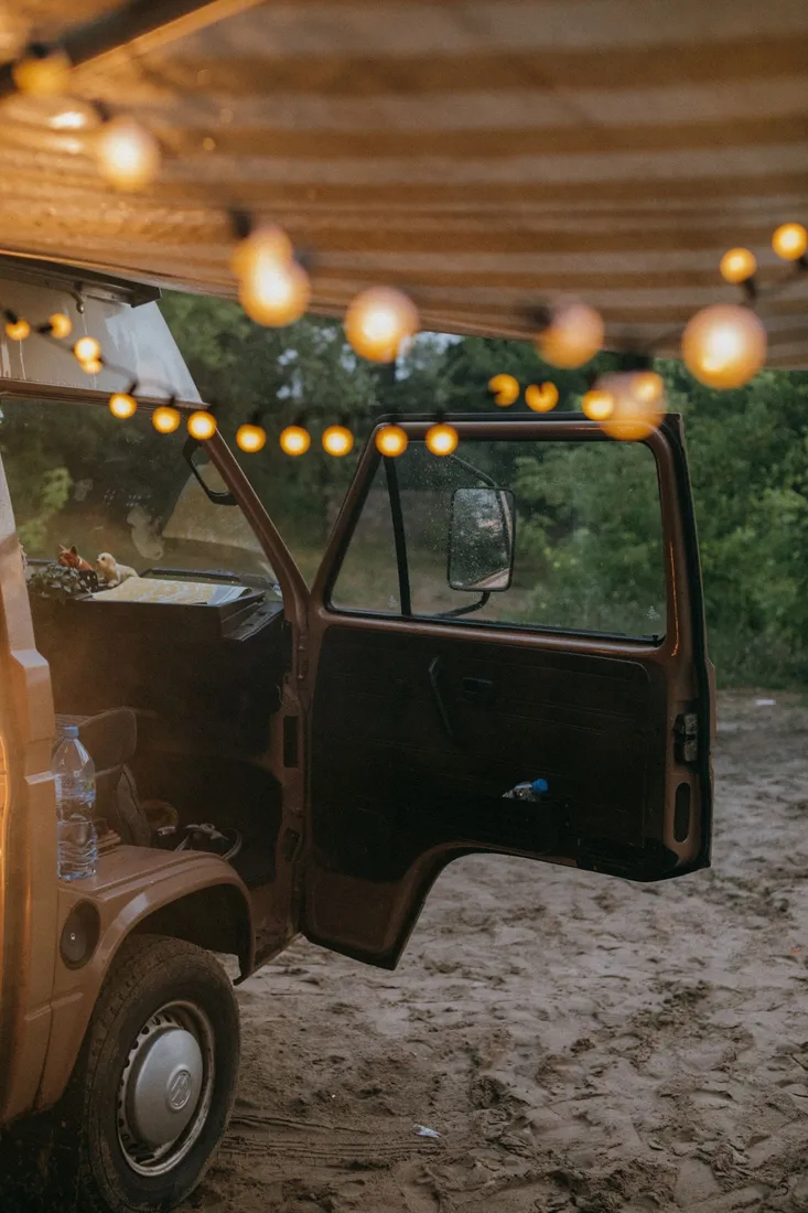 Geöffnete Tür eines Campingbusses mit Lichterkette