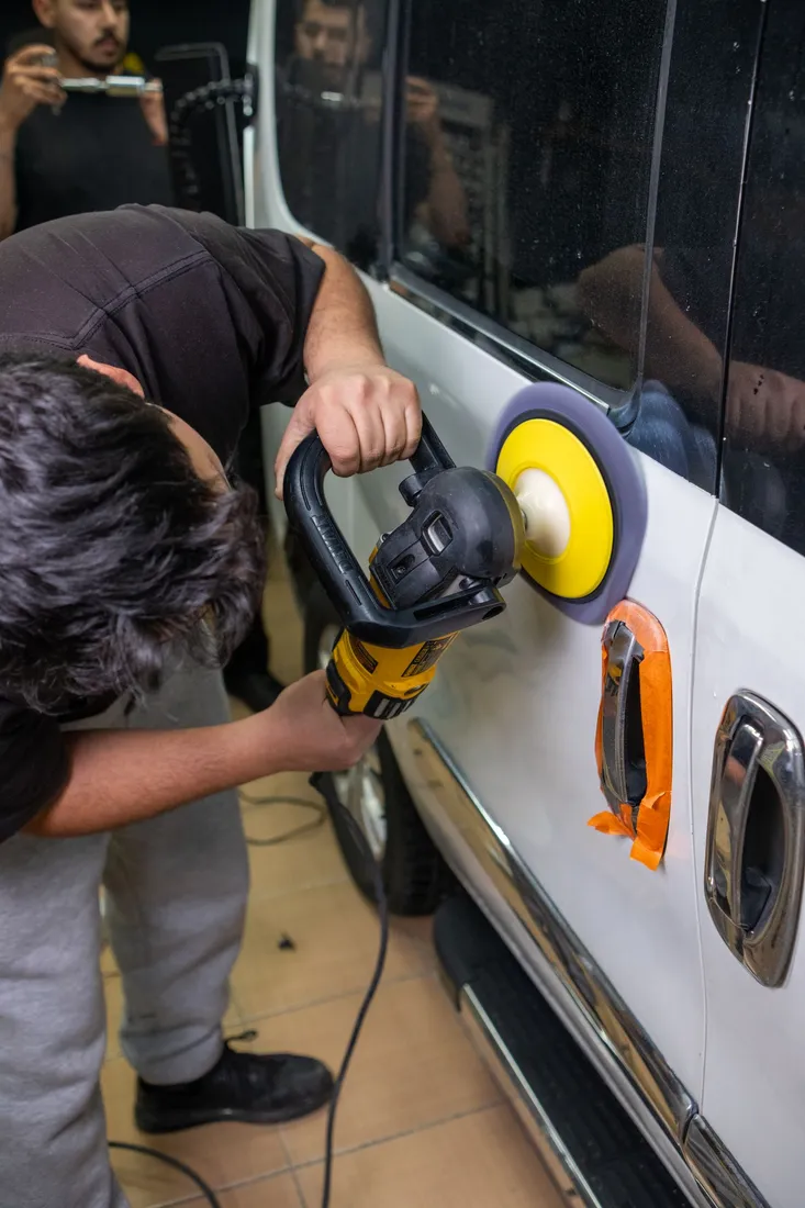 Autotür wird mit einer elektrischen Poliermaschine bearbeitet