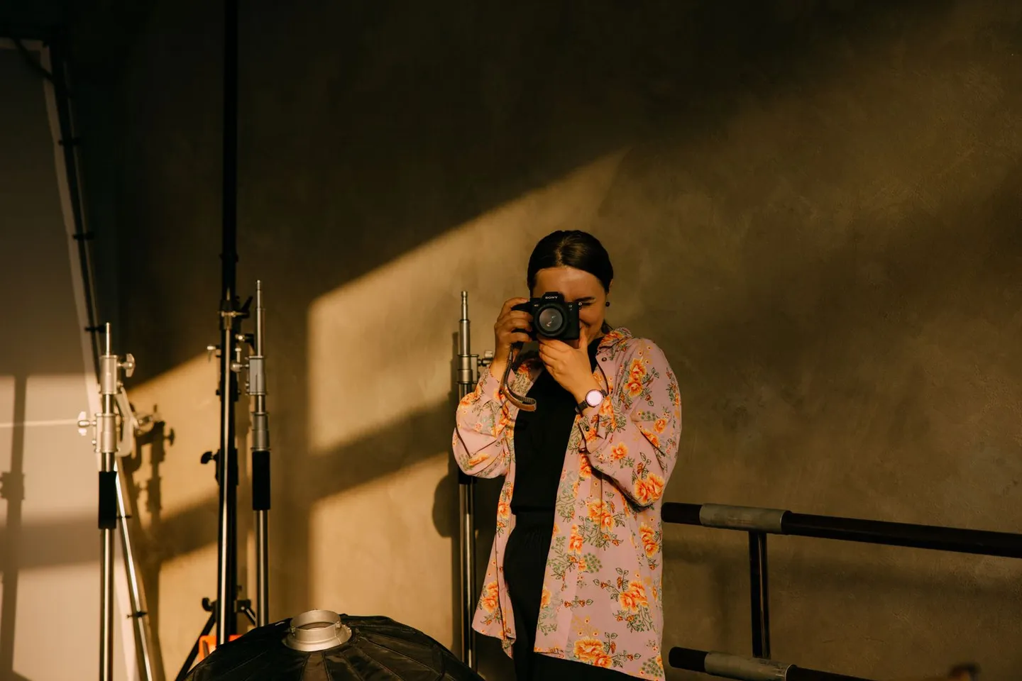 Person mit Kamera zwischen Leuchten in einem Fotostudio