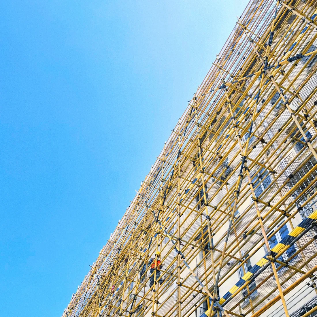 Mehrstöckiges Baugerüst vor blauem Himmel