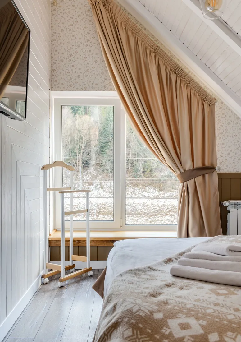 Helles Schlafzimmer mit großen Fenstern und Vorhängen