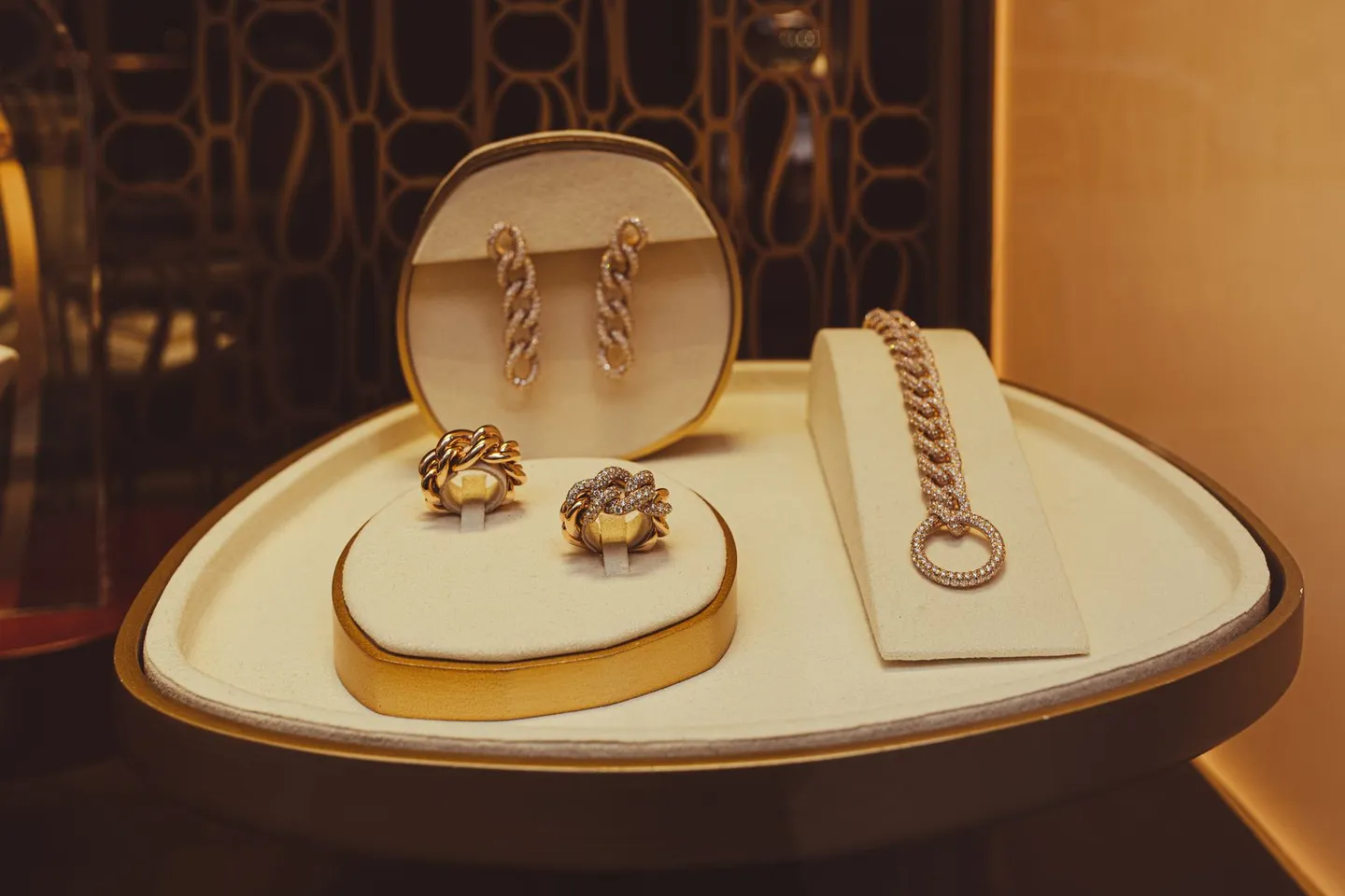 Schmuckpräsentation mit goldfarbenen Ringen, Ohrringen und Kette
