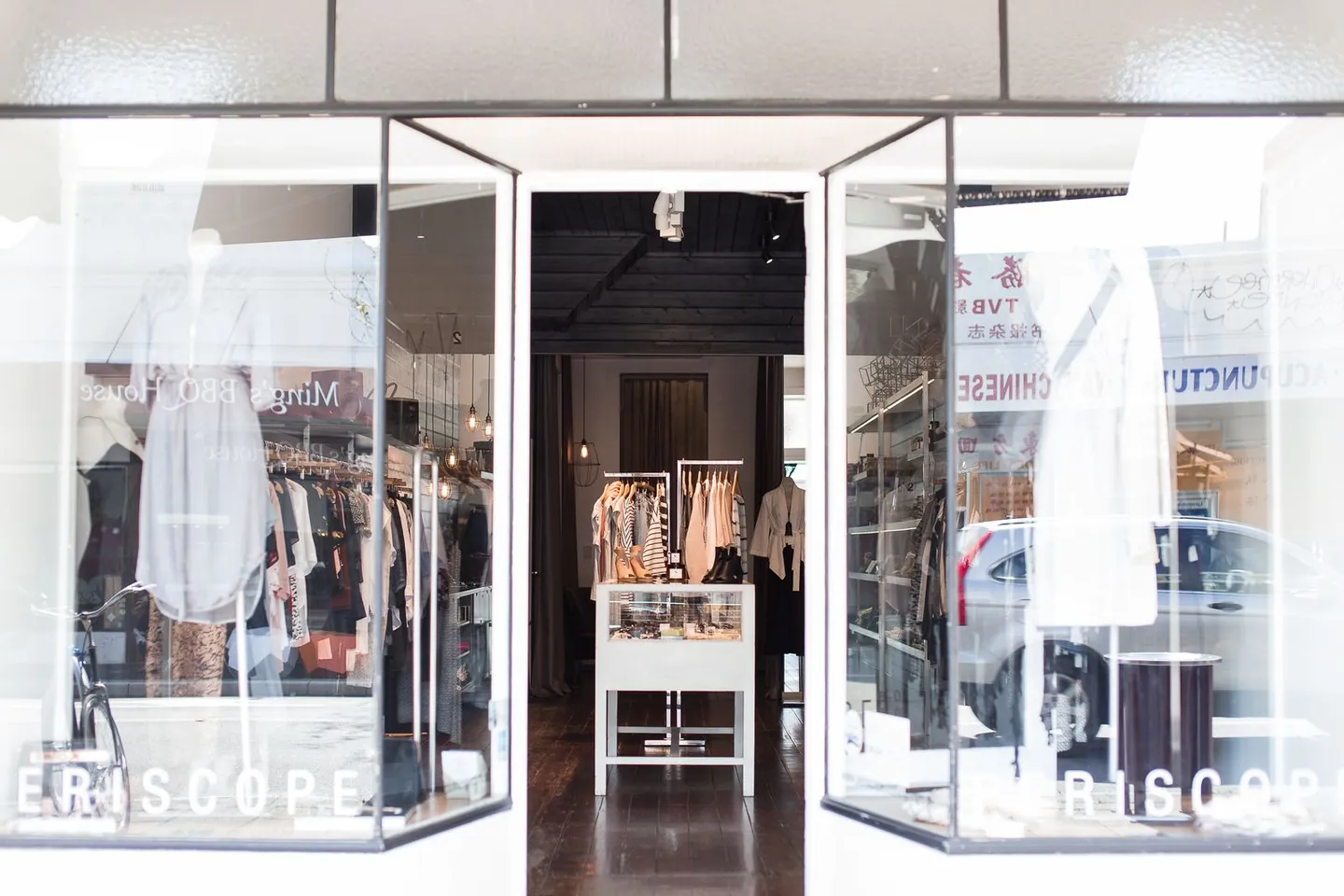 Eingang einer Boutique mit Kleidungsstücken im Schaufenster