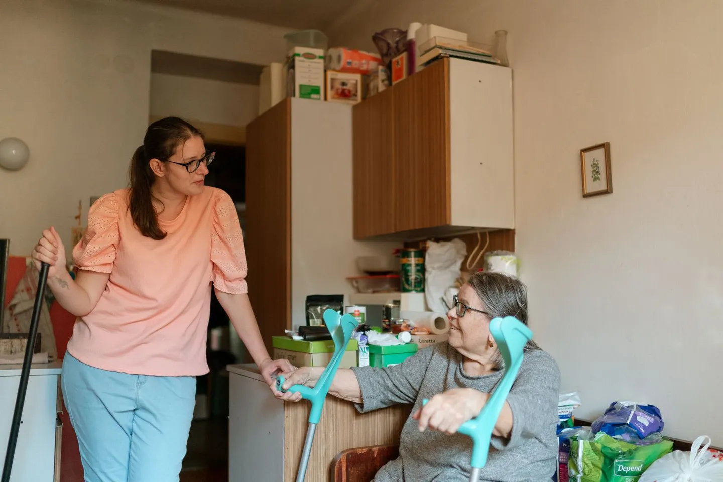 Zwei Frauen mit Gehhilfen im Gespräch in einem Wohnraum