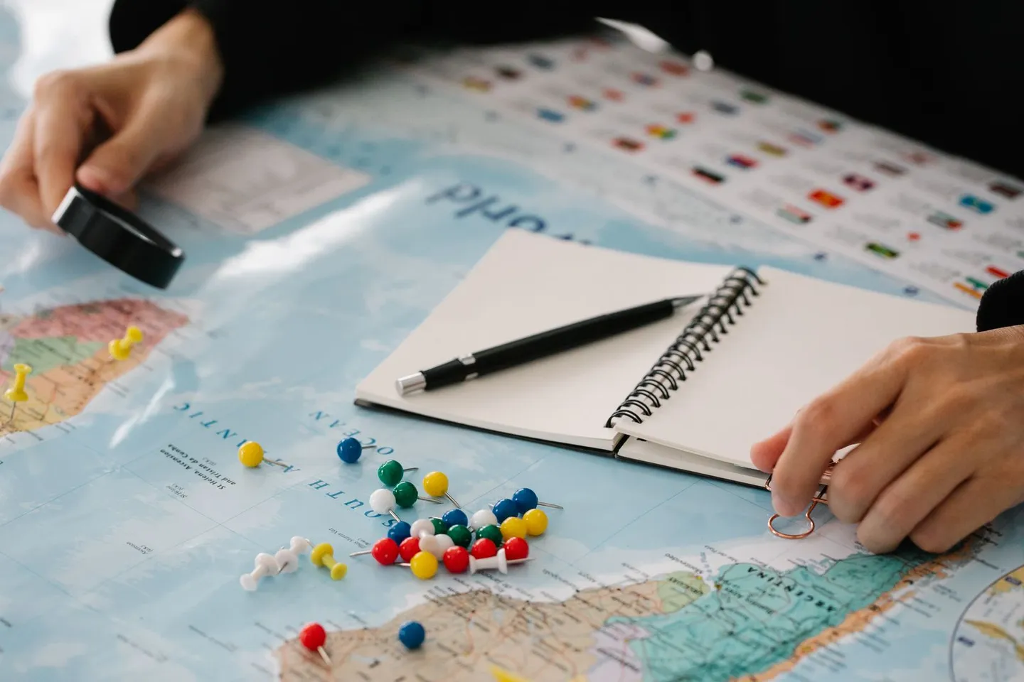 Reiseplanung mit Landkarte, Stecknadeln und Notizblock