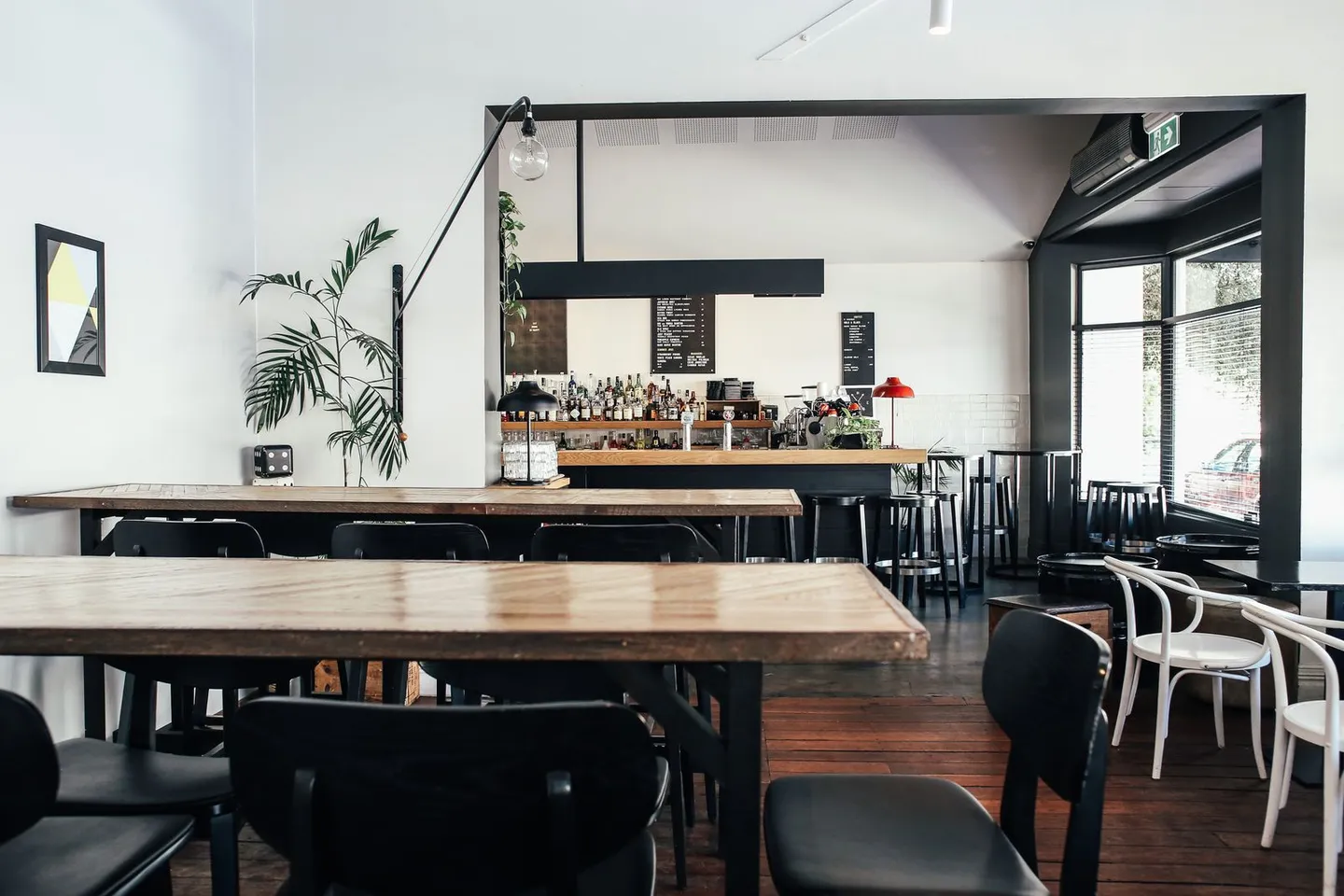 Restaurant mit Holztischen, Stühlen und einer Bar
