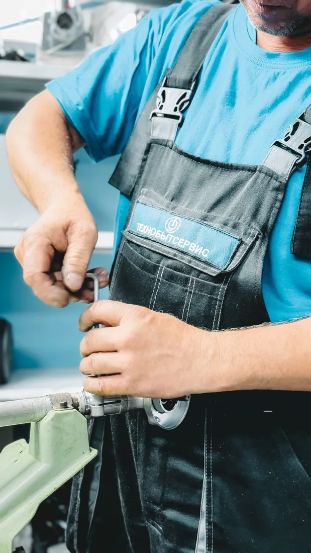 Hände bearbeiten ein Rohrteil mit einem Werkzeug